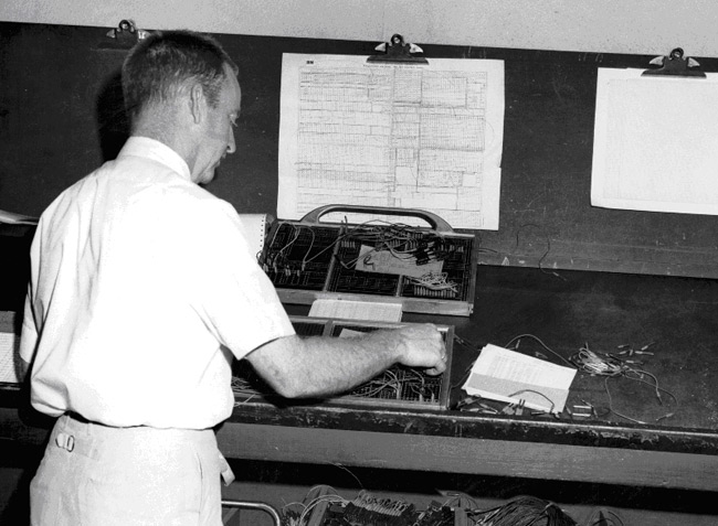 NWRC employee Garland O’Shields performs complex wiring on an accounting machine plug board which did addition and subtraction calculations.