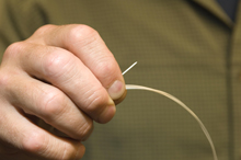 A sample of fiber optic cable 1/32 of an inch thick.