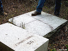 early stone baseline monument with a bolt and an x etched in its center