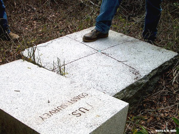 early stone baseline monument with a bolt and an x etched in its center