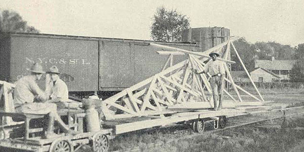 A smaller tower being hauled, still assembled, on a trailer to a new survey site