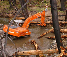 woody debris is placed in a stream to create habitat suitable for spawning salmon. woody debris is placed in a stream to create habitat suitable for spawning salmon